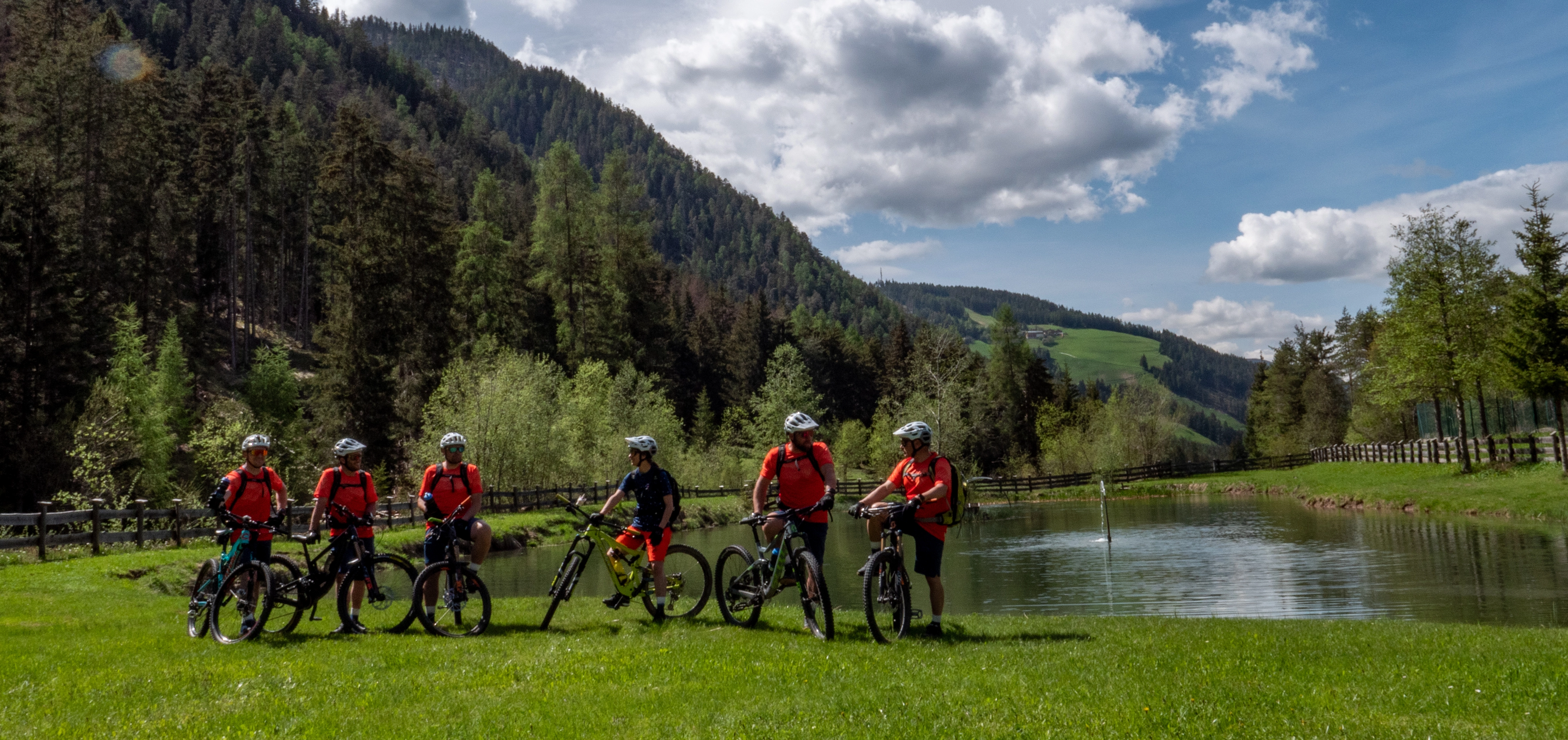 Bikeguides vor einem See in den Dolomiten, alle haben Spaß